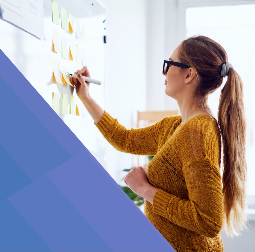 Woman writing on a whiteboard during a brainstorming session