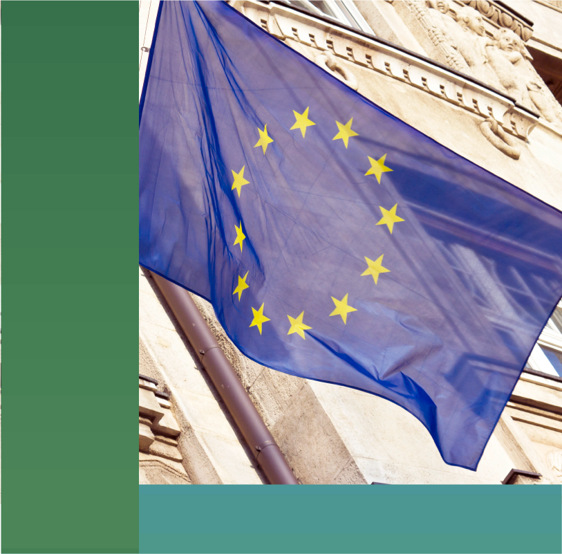 Close up shot of the European Union flag hanging from a building.