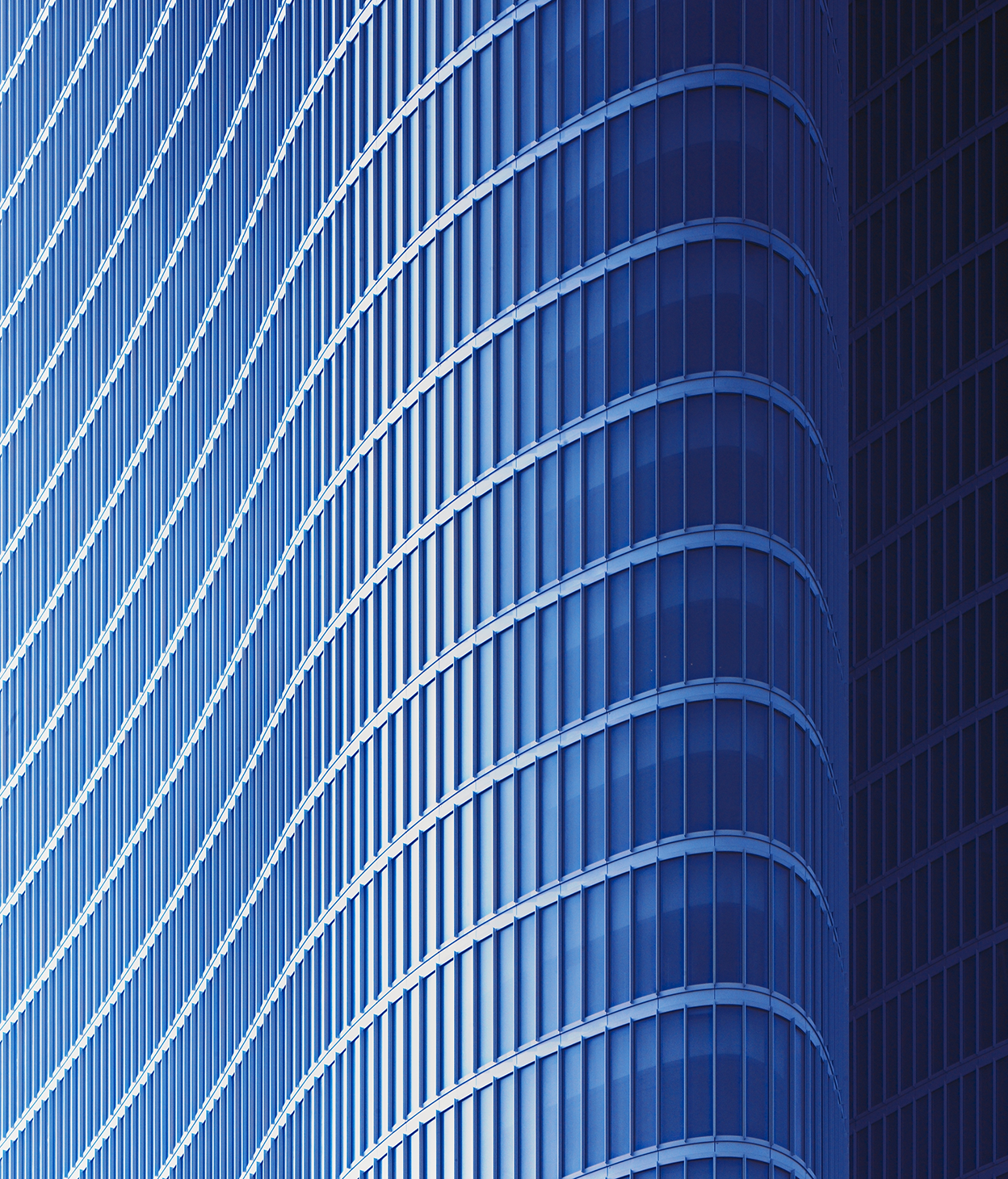 Foto ravvicinata di una facciata curva in vetro di un edificio per uffici.